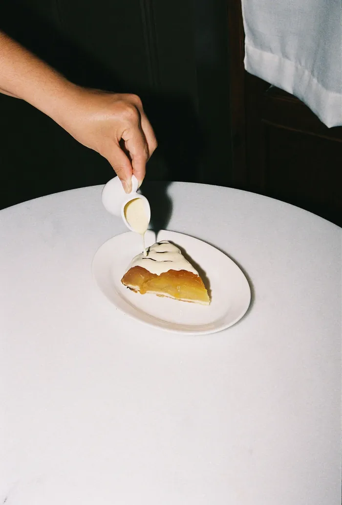 Una mà aboca crema sobre un postre
