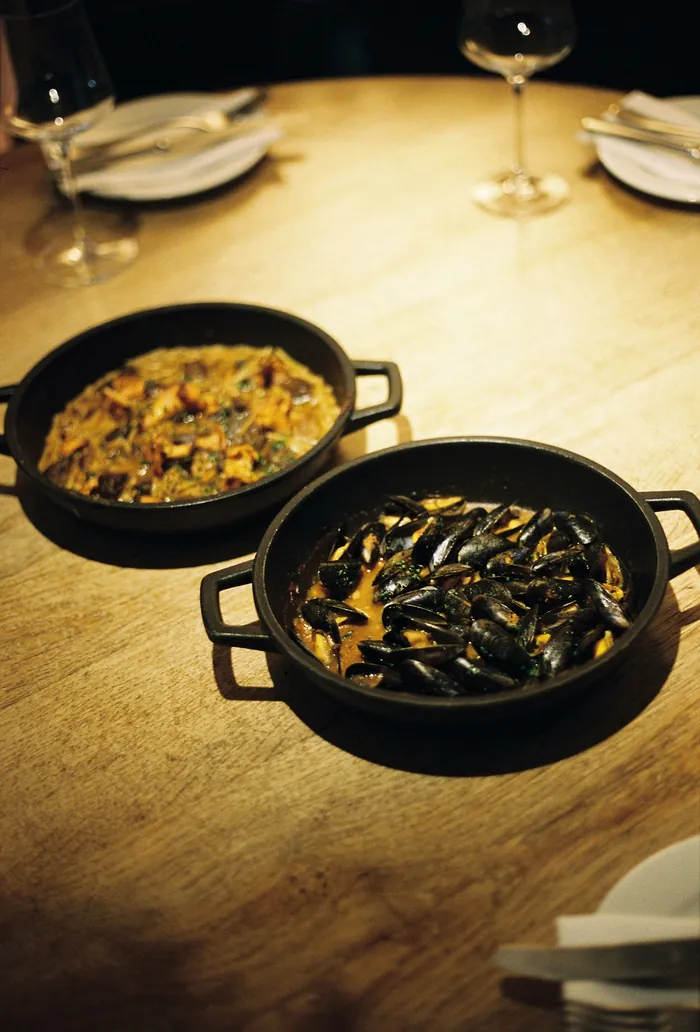 Dues cassoles a la taula: fideus amb bolets i musclos en suquet